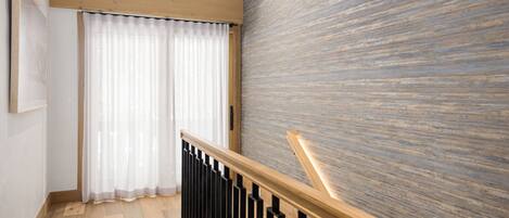A staircase with wooden railings and a textured wall.