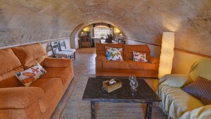 A cozy room with two orange sofas, a dark coffee table, and a patterned rug. - Hort de Sa Barrala, a small finca near Ses Covetes - Es Trenc beach (Ses Salines)