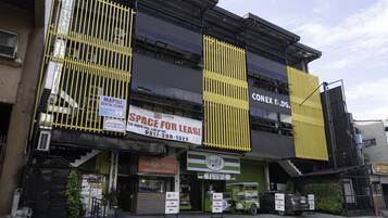 A building with multiple storefronts, including a dental clinic and a restaurant named 'The Barn'.