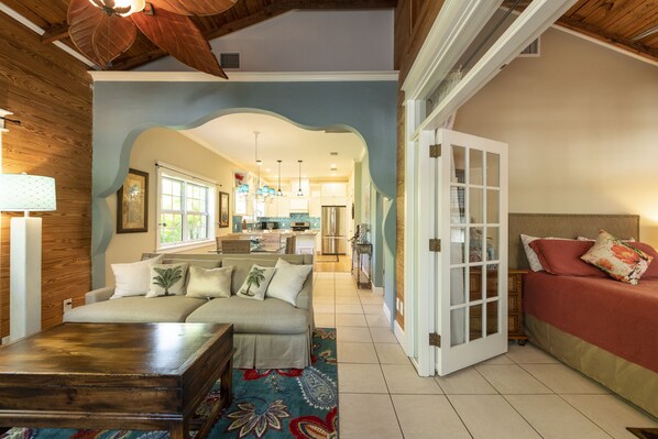 A cozy living room with a sofa, a coffee table, and a patterned rug. - THE MANGO TREE COTTAGE - Old Town Key West, Steps to Duval Street (Key West)