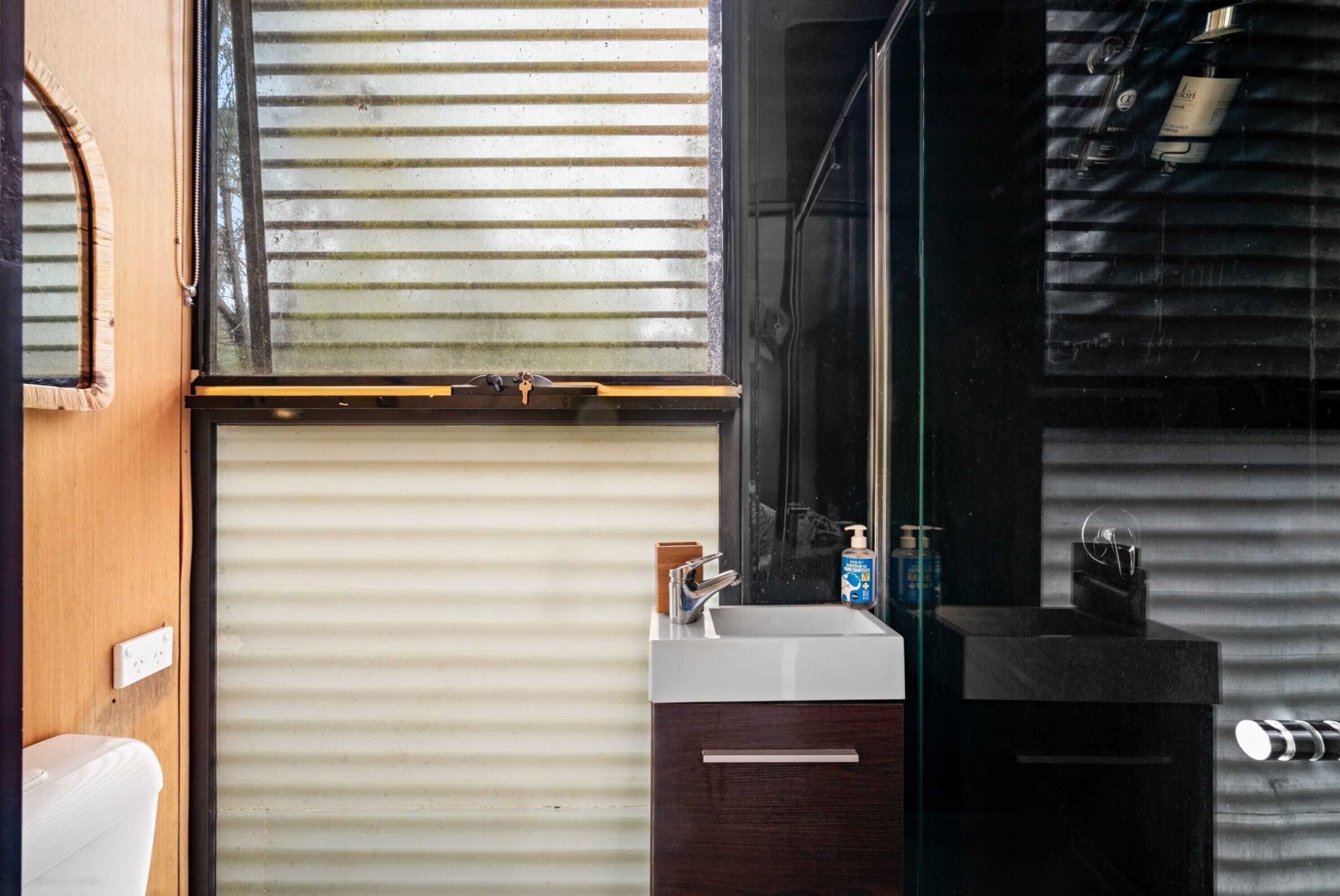 A bathroom with a toilet, sink, and mirror.