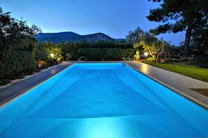 Une piscine rectangulaire offrant une vue sur les montagnes en arrière-plan.