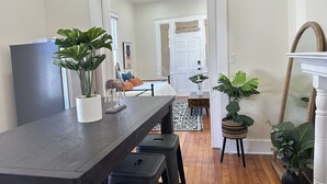 Een moderne keuken met een donker houten aanrecht, zwarte krukken en potplanten.