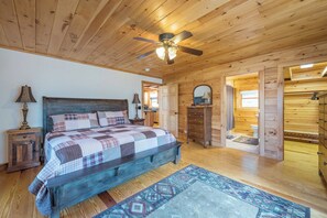 A wooden cabin bedroom with a bed, a ceiling fan, a nightstand, and a dresser. - Bearadise Mtn Cabin~Hot Tub+Fire Pit, Grill & WiFi (Burnsville)