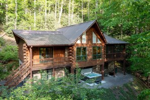 A log cabin with a balcony, a hot tub, and a deck. - Bearadise Mtn Cabin~Hot Tub+Fire Pit, Grill & WiFi (Burnsville)