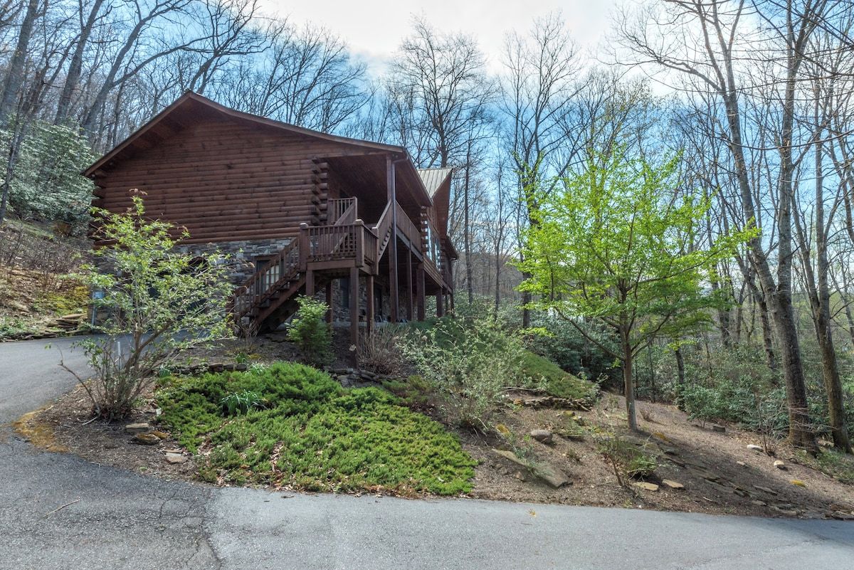 A log cabin with a porch and a staircase leading to the entrance.
