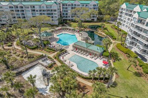 Un resort con varias piscinas, campo de golf y jardines exuberantes.