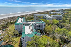 Een resort met meerdere gebouwen, een zwembad en uitzicht op het strand.