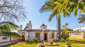 A traditional house with a tiled roof, a stone wall, and a fountain in the garden. - Villa Jardin de Mari by Solset (Málaga)