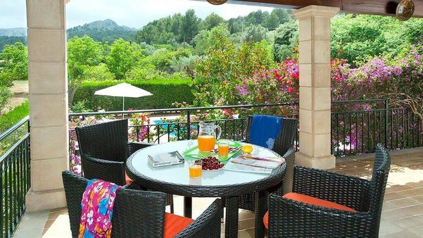 A round table with wicker chairs and a white umbrella on a balcony with a view of greenery and mountains. - Villa Rotger, Comfortable and traditional at 800m. from Pollensa (Pollença)
