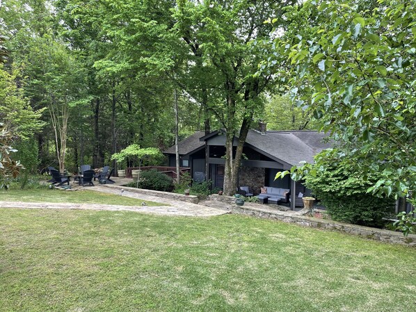 A cabin with a stone exterior, a deck, and outdoor seating.