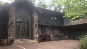 A two-story stone house with a front porch, a garage, and a driveway. - Family Retreat on Eden Isle Sleeps 12+ with 2 golf carts 4500 sq. ft.  (Heber Springs)
