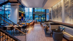 A modern interior with a bar area, seating, and a staircase.