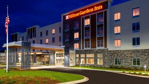 A Hilton Garden Inn hotel with a modern design, featuring a stone facade and multiple windows.