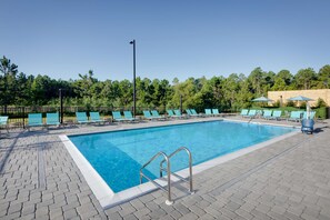 A rectangular swimming pool with a metal ladder, surrounded by a paved walkway. - Hilton Garden Inn Panama City Airport (Panama City)