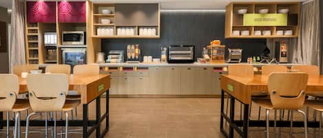 A modern kitchen with wooden cabinets, a microwave, and a coffee machine.