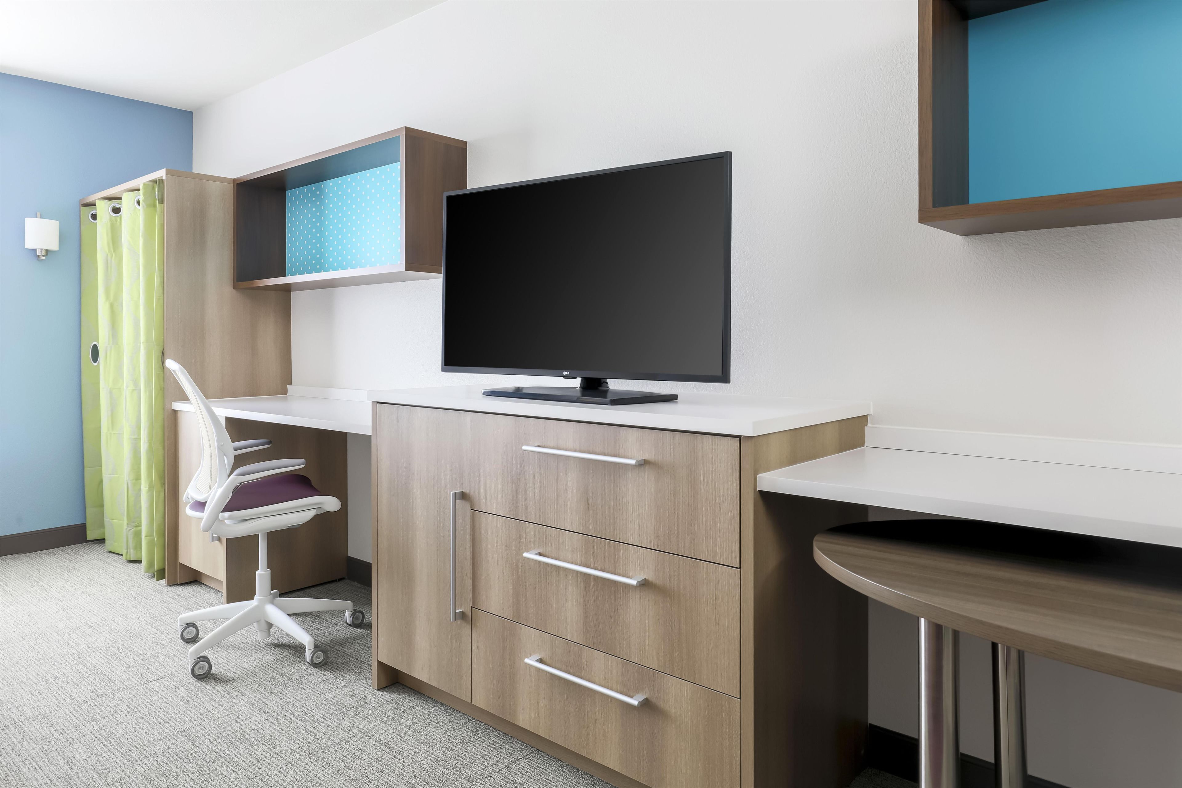 A medical examination room with a desk, a computer monitor, a chair, and a cabinet.