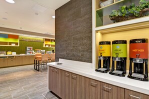 Een moderne keukenhoek met een koffiehoek, inclusief dispensers met de aanduidingen 'Bourmet', 'Decaf' en 'Heet H2O'.