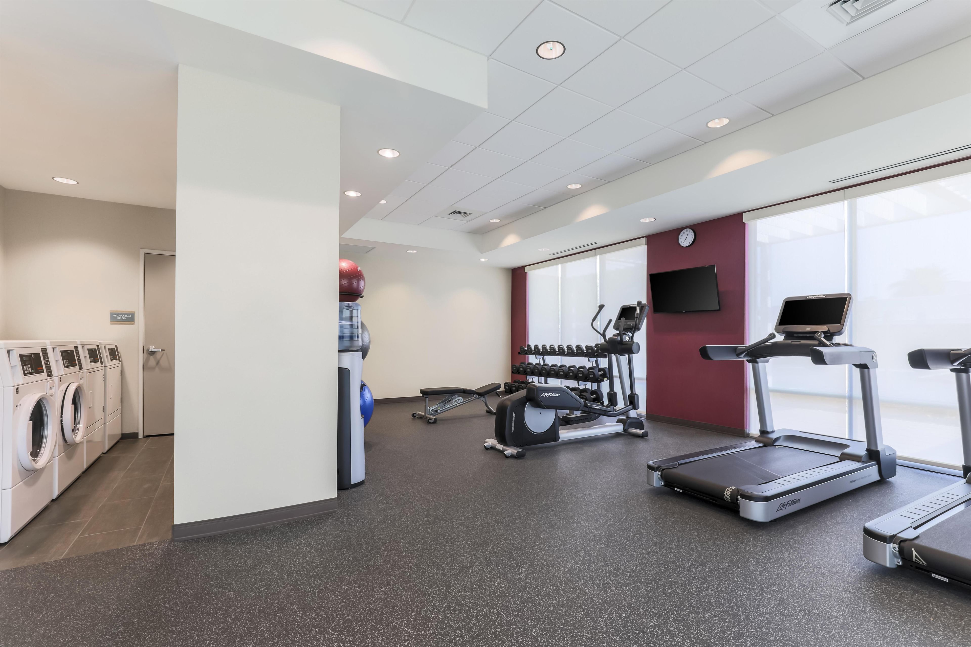 Una palestra attrezzata con tapis roulant, ellittiche e macchinari per pesi.