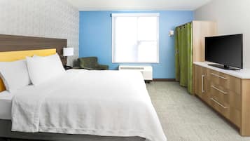 Una habitación de hotel con cama, televisión, escritorio y ventana.