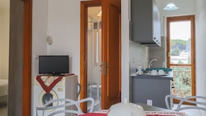 A compact living space with a dining area, a kitchen, and a view of the outdoors. - Apartment in Capaccio ID 3888 (Licinella-Torre di Paestum)