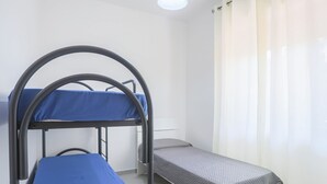 Een slaapzaal met stapelbedden en een eenpersoonsbed.