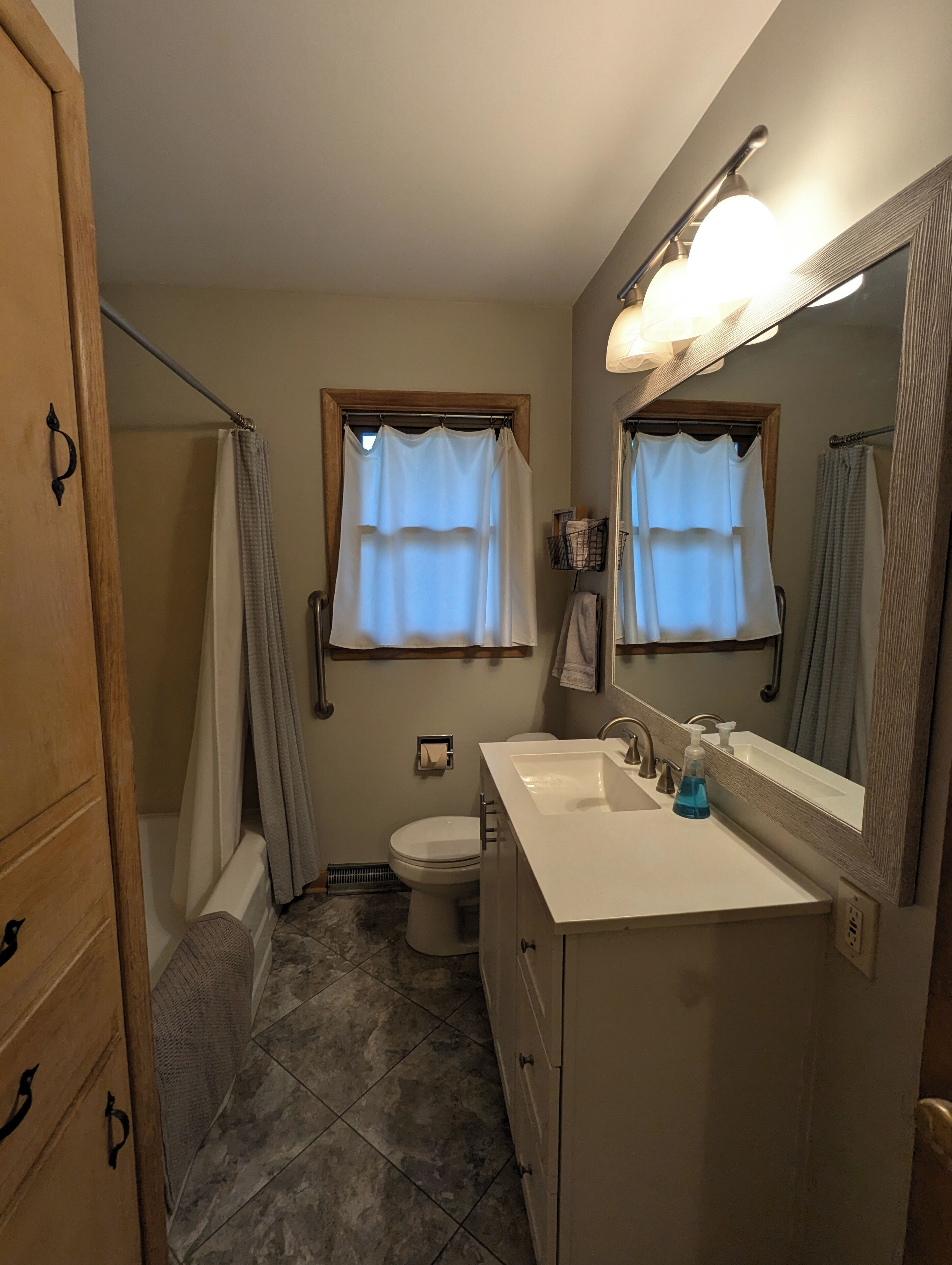 A bathroom with a shower, toilet, and sink.