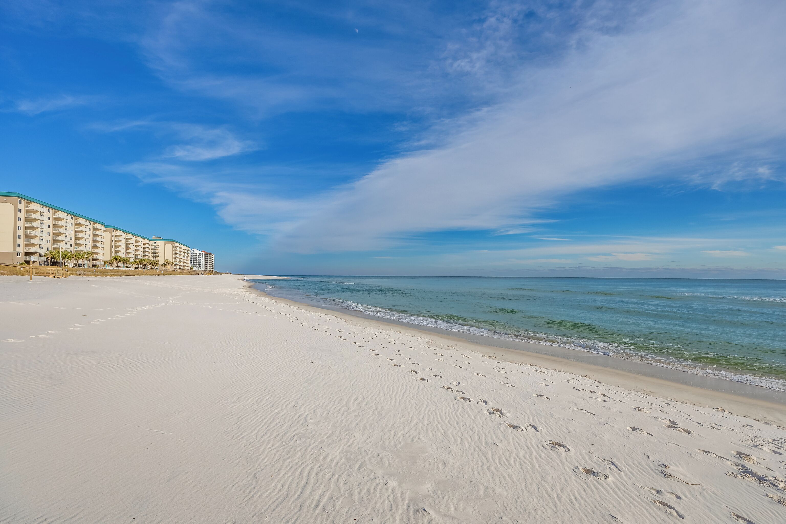 Une plage bordée d’une rangée de bâtiments.