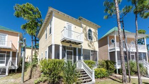 A two-story building with a balcony, a porch, and a staircase leading to the entrance. - Exquisite Condo Retreat, Lagoon Oasis Pool & Pristine Beaches: No Problem (Pensacola)
