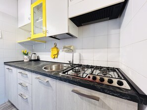 Kjøleskap, kjøkkenutstyr og spisebord