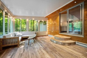 Um interior moderno com parede de madeira, janelas amplas e um banco embutido.