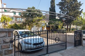Secure gated community with an entrance and a building with a tiled roof.