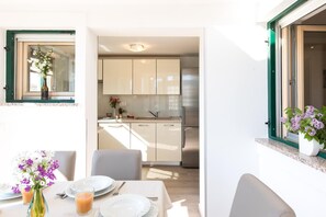 Enjoy meals in this kitchen with a refrigerator, sink, and dining area for two.