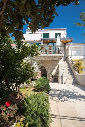Step into a charming Mediterranean haven with a balcony overlooking a lush garden.