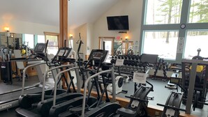 Uma academia com esteiras, elípticos e aparelhos de musculação.