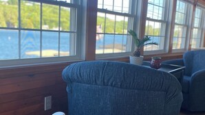 Una habitación con ventanas amplias, una planta en maceta y una mesa.