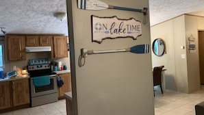 Una cocina con armarios de madera, una estufa y un letrero que dice "ON lake TIME".