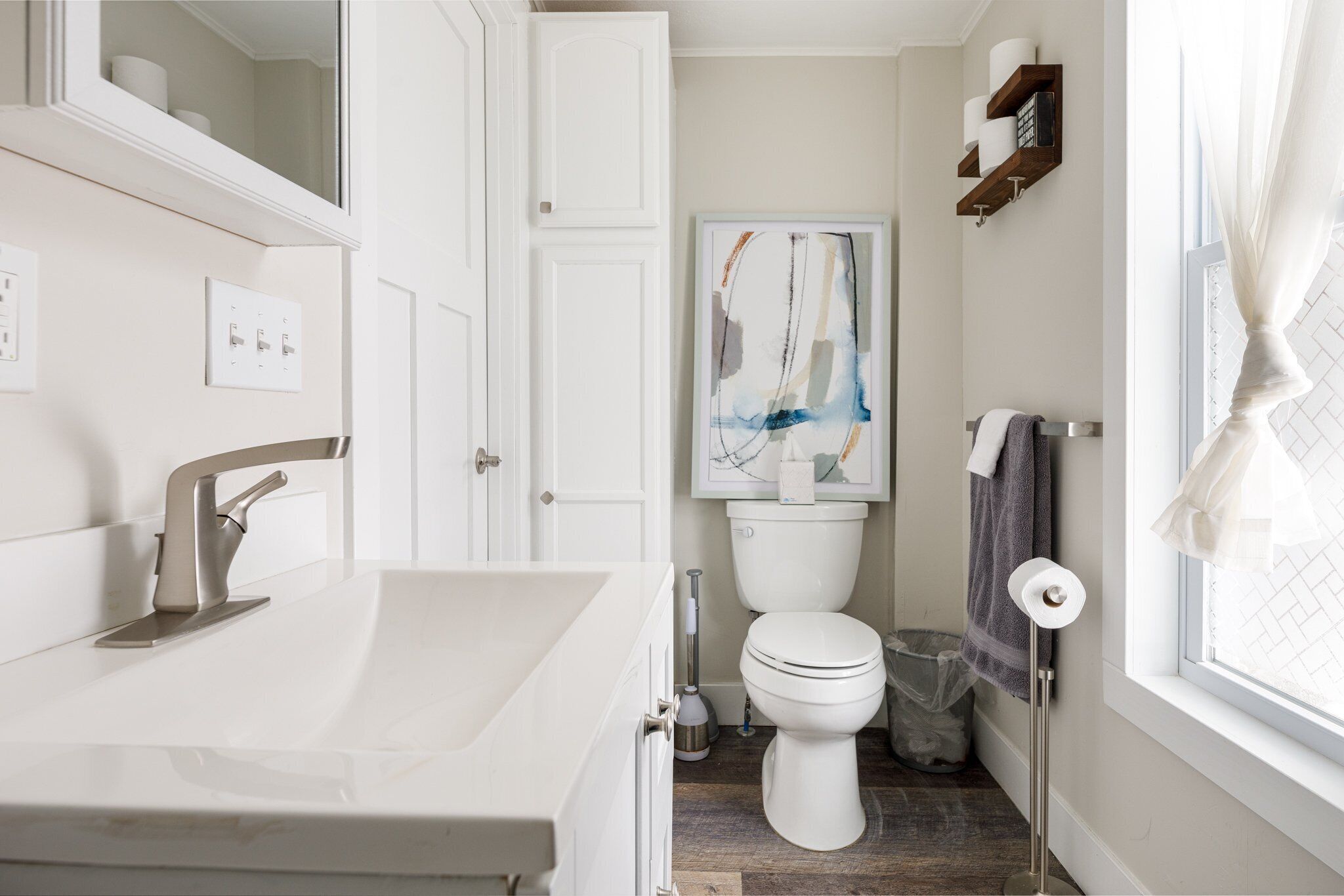 A modern bathroom with a white sink, a toilet, and a shower area.