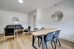 Un salon moderne comprenant un canapé, des fauteuils, une table basse et une table à manger.