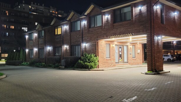 Un motel avec un panneau indicateur, une allée et une entrée.