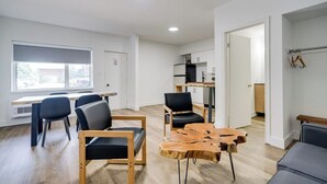 A modern living room with a dining area, a kitchen, and a view of the outside. - Toronto Lakeshore Hotel (Mississauga)