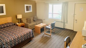 Une chambre d’hôtel avec un lit, un canapé, un bureau et une chaise.