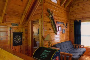 Relax in this charming cabin-style room with a wooden ceiling, comfortable sofa, and cozy table area.
