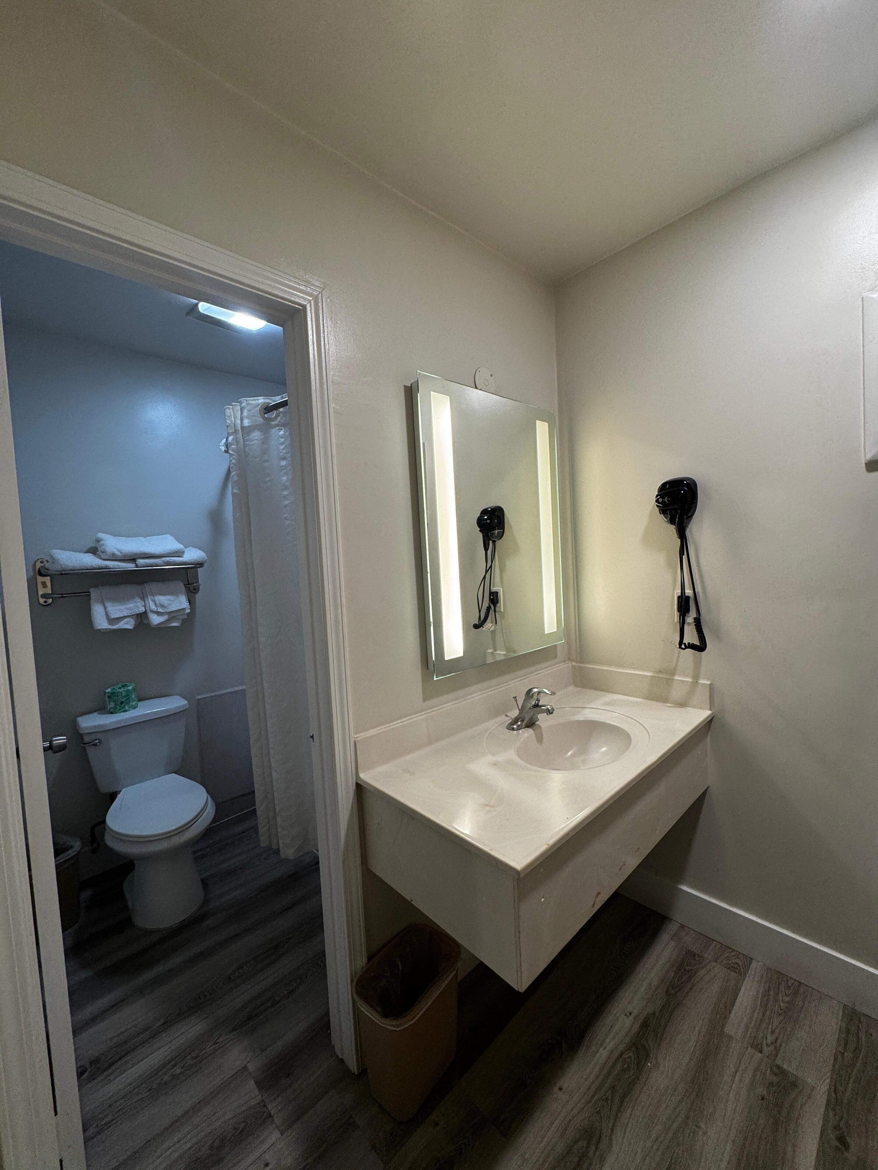 Ein Badezimmer mit Waschbecken, Spiegel und Toilette.