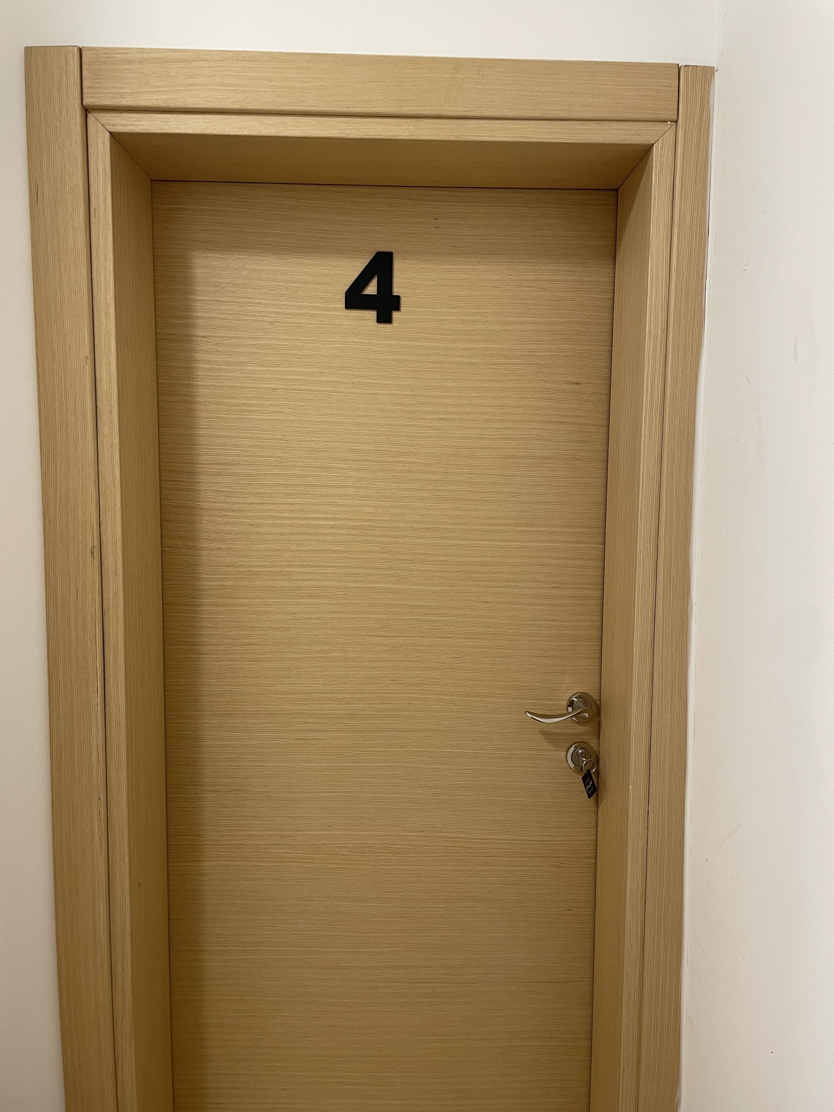A wooden door with a number '4' on it, a keyhole, and a door handle.