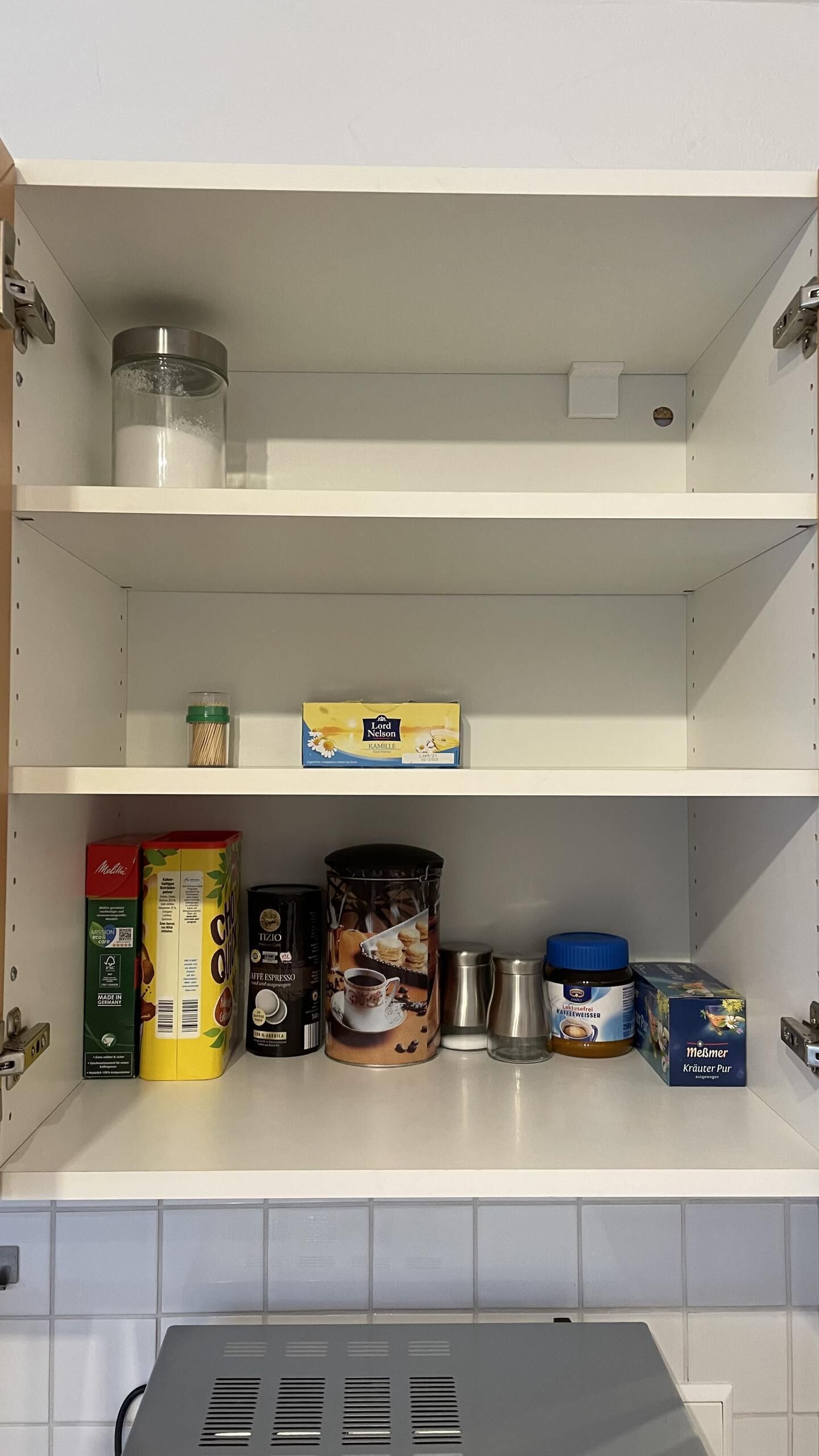 A kitchen pantry with shelves containing various food items and containers.