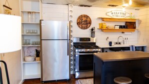 Une cuisine moderne dotée d’appareils électroménagers en acier inoxydable, de touches décoratives en bois et d’une enseigne accueillante.