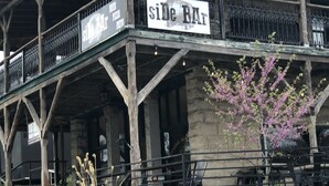 Un bâtiment sur lequel on peut lire l’inscription « SiDe Bar » et qui possède un balcon avec des balustrades.