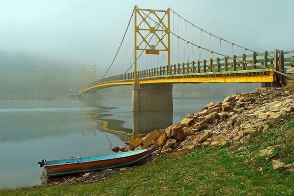Un ponte sopra un fiume tranquillo, con una barca sulla riva.
