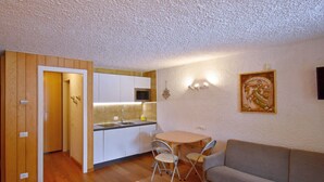 Quarto compacto com cozinha compacta, área de refeições e sofá.